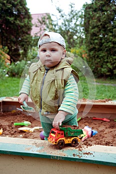 Working boy playing in a sandbox