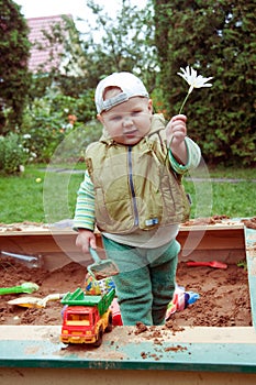 Working boy playing in a sandbox