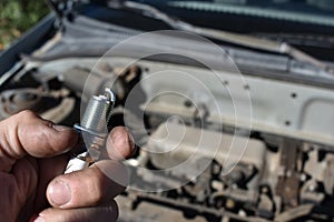 Working on Car Changing Spark Plugs Under the Hood