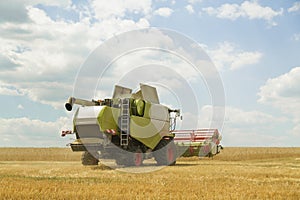 Working combine harvester in a wheat field. Agricultural background.