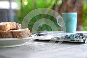 Working on the computer and cell phone while having breakfast