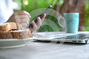 Working on the computer and cell phone while having breakfast