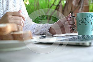 Working on the computer and cell phone while having breakfast