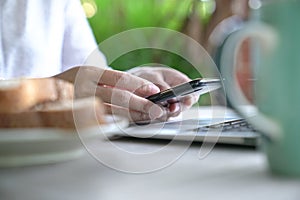 Working on the computer and cell phone while having breakfast