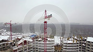 A working construction crane above the building construction area