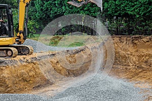 Working on a construction excavator moving gravel stones for foundation building