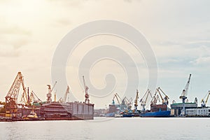Working crane bridge in shipyard and cargo ships in a port