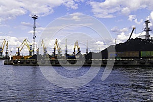 Working crane in the port, coal terminal, containers