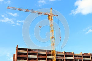 Working crane and red brick residential building