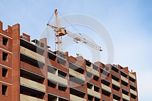 Working crane and red brick residential building