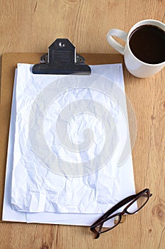 Working with crumpled paper,coffee cup, and pen on wooden table background