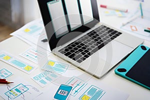 Working desk of programmer developing technologies mobile phone with sketch application on table. User experience concept