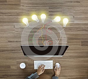 Working on desktop computer with creative light bulb ideas