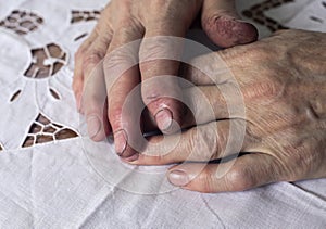 Working dirty hands of senior woman after work, lying on table, closeup