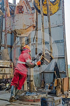 A working driller lifts drill pipes from a well.