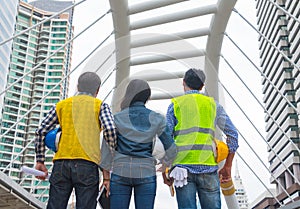 Working engineer.They are see sky and building mean teamwork and spirit beside building background.