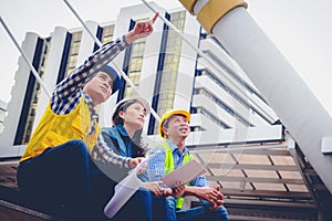 Working engineer.They are talking and plant for work with equipment beside building background.