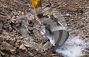 Working excavator bucket. Sparking. Dusty construction site