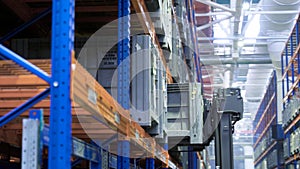 Working in factory warehouse. Scene. Technology for placing containers on shelves in warehouse of enterprise. Automated