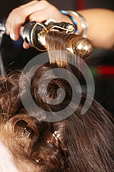 Working Hairstylist Curling Hair in a Salon photo