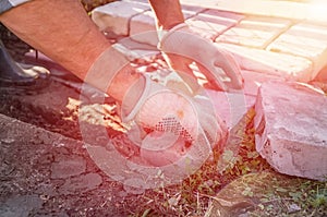 Working hands lay brick masonry in cement mortar