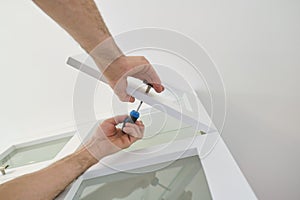 Working hands of male carpenter assembling furniture