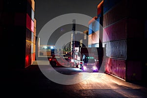 Working at the harbor at night, the container carrier is loading the trucks into the truck