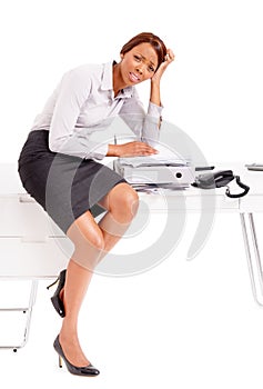 Working hard. An overtired ethnic business woman sitting on her desk. photo
