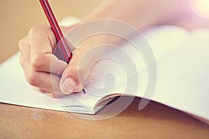 Working hard at school. A cropped closeup image of a child writing in a workbook.