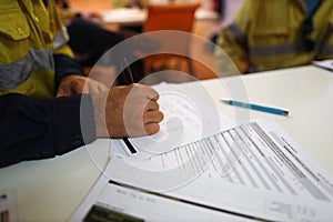 Working at heights permit book placing on the table, defocused construction site supervisor reviewing job hazard analysis