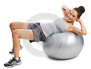 Working on her balance and strength. A gorgeous young woman doing exercises with a pilates ball.