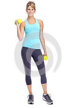 Working on her fitness. Attractive young woman in sportswear lifting dumbbells while isolated on white.