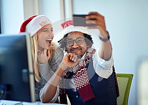 Working at holiday at office.Business people  work at Christmas and  take selfie in santa hat