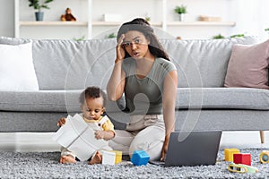 Stressed Black Mother Trying To Work At Home While Baby Distracting Her
