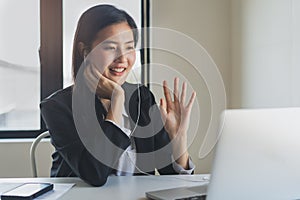 Working from home using internet communication concept. Asian young woman wear earphones talking  in video conference with