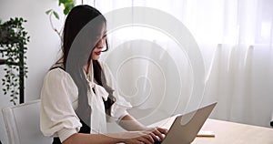 A working Japanese woman typing laptop by remote work in the home office closeup