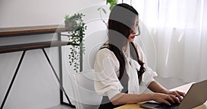 A working Japanese woman typing laptop by remote work in the home office closeup