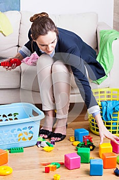 Working lady cleaning up toys