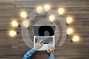Working on laptop computer PC with creative light bulb ideas