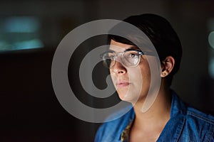 Working late to complete her assignment. Cropped shot of a young woman working late in her office.