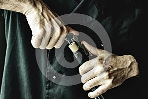 Male hands uncorking wine bottle