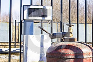 The working man has controlled gas cylinder propane closeup, the background is blurred with bokeh effect