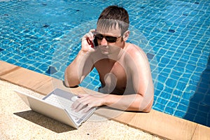Working man with laptop in pool