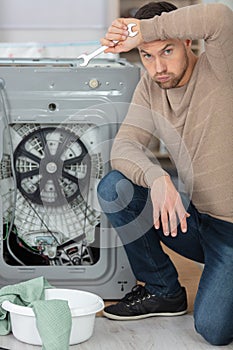 working man plumber repairing washing machine