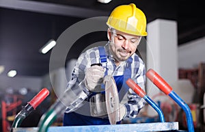 Working man practicing his skills with angle grinder at workshop