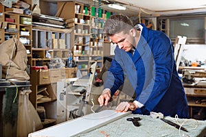 Working man practising his skills in plank chiseling