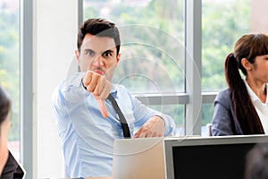 Working man show thumb down with group of people in metting room, focus on hand , bad concept