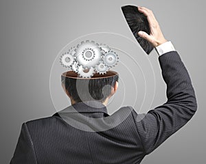 Working metal gears inside businessman's head