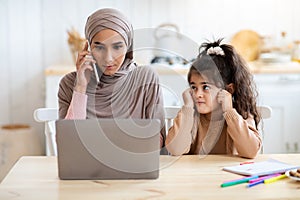 Working Mom. Bored Little Arab Girl Sitting Next To Her Busy Mother