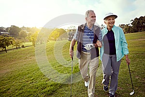 Working on more than their game. a smiling senior couple enjoying a day on the golf course.